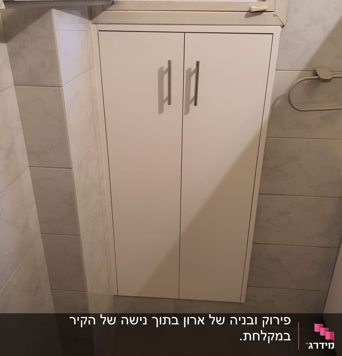 ארון עץ לבן עם ידיות מתכת בחדר אמבטיה